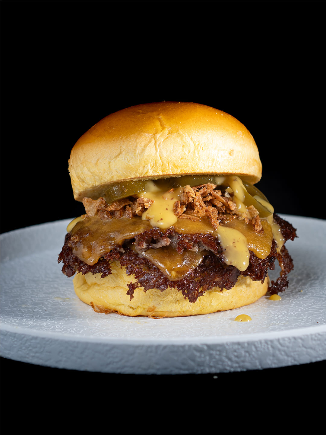 Hamburguesa con carne smash, queso cheddar, pepinillos y cebolla picada en Cádiz