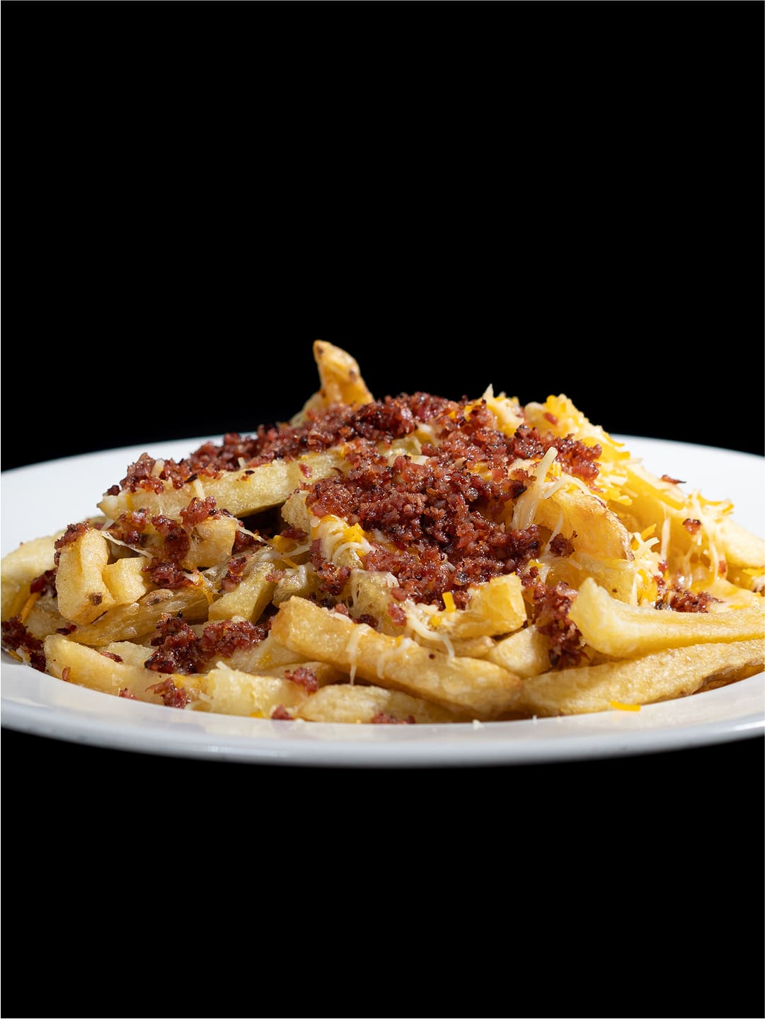 Ración de patatas fritas con queso cheddar rallado y bacon crujiente en Las Salinas Smash Burger, El Puerto de Santa María